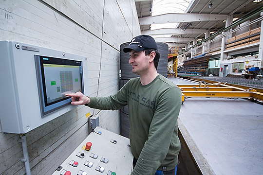 Der große Touch-Bildschirm mitten in der Produktion visualisiert die Umlaufanlage und die Härtekammerbelegung